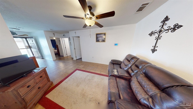 living room featuring ceiling fan and a textured ceiling