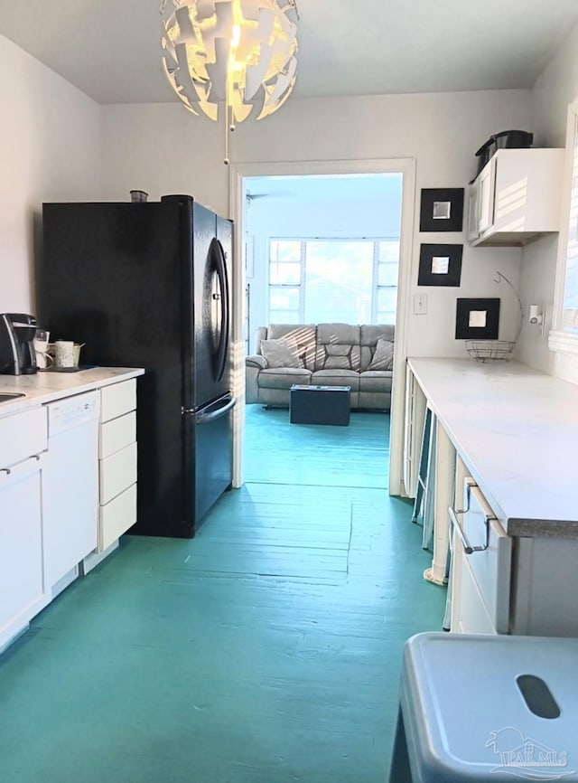 kitchen featuring white dishwasher, white cabinets, wood finished floors, and freestanding refrigerator