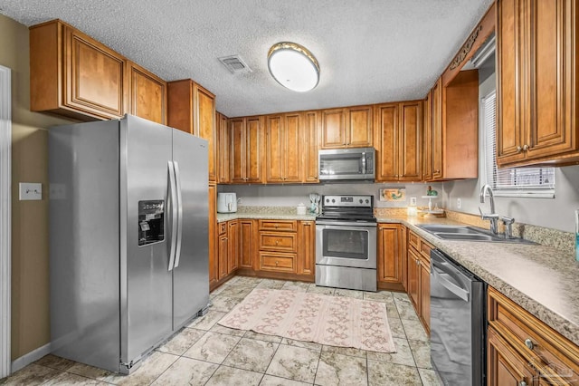 2762 Christine St, Pensacola, FL 32526 - kitchen with stainless steel appliances, brown cabinetry, a textured ceiling, and light countertops