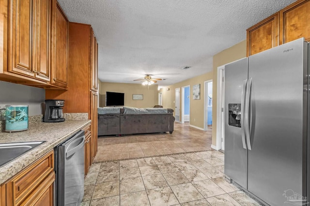 2762 Christine St, Pensacola, FL 32526 - kitchen featuring appliances with stainless steel finishes, brown cabinets, open floor plan, light countertops, and a textured ceiling
