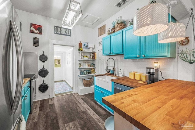 1220 E Cervantes, Pensacola, FL 32501 - kitchen featuring blue cabinetry, butcher block countertops, appliances with stainless steel finishes, a sink, and dark wood-style floors