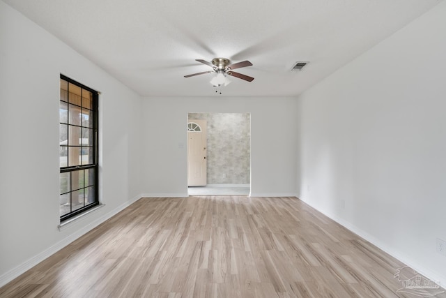 unfurnished room featuring ceiling fan, light hardwood / wood-style flooring, and a textured ceiling