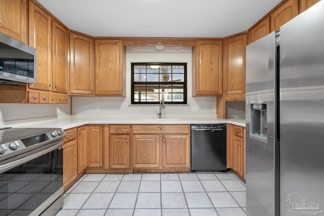 kitchen with stainless steel appliances, sink, and light tile patterned floors