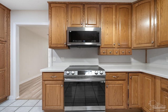 kitchen featuring light tile patterned floors and stainless steel appliances