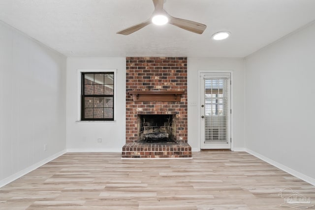 unfurnished living room featuring light hardwood / wood-style flooring, a textured ceiling, a fireplace, and ceiling fan