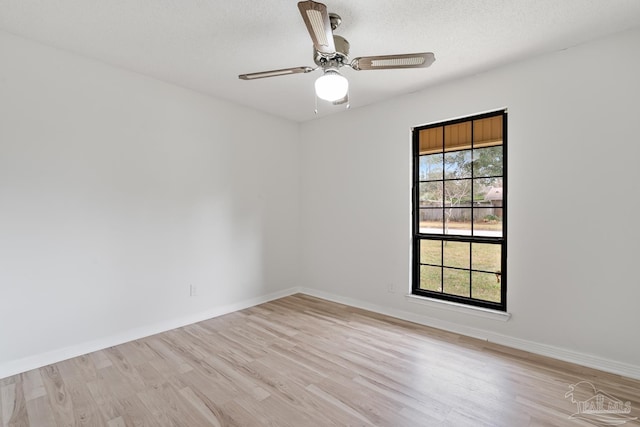 spare room with a textured ceiling, light hardwood / wood-style floors, and ceiling fan