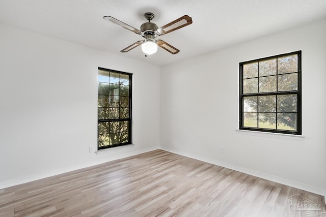 unfurnished room with ceiling fan, light hardwood / wood-style flooring, and a textured ceiling