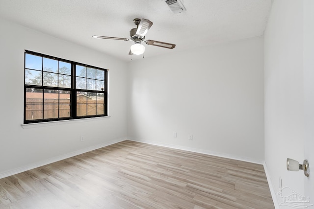 spare room featuring a textured ceiling, light hardwood / wood-style flooring, and ceiling fan