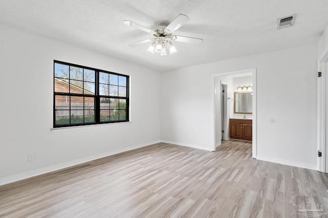 empty room featuring ceiling fan, a textured ceiling, and light hardwood / wood-style floors