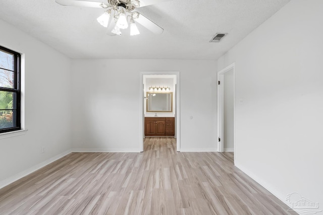 unfurnished room featuring ceiling fan, a textured ceiling, and light wood-type flooring