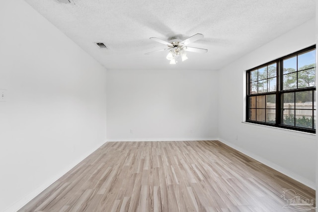 unfurnished room with ceiling fan, a textured ceiling, and light wood-type flooring