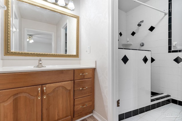 bathroom featuring tiled shower and vanity