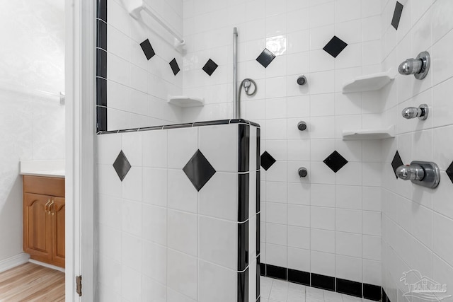 bathroom featuring hardwood / wood-style flooring and a tile shower