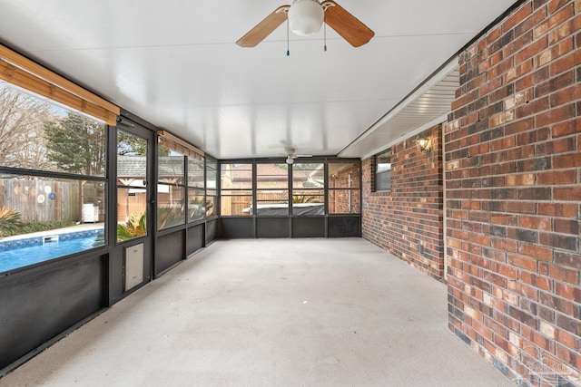 unfurnished sunroom with ceiling fan