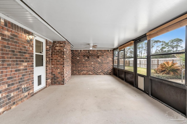 unfurnished sunroom with ceiling fan