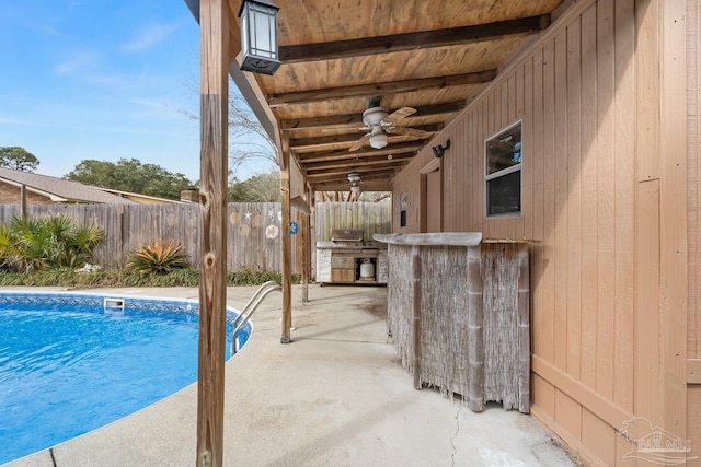 view of swimming pool with an outdoor bar, ceiling fan, and a patio area