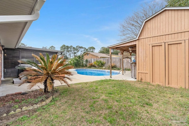 view of yard featuring a fenced in pool, an outdoor structure, a sunroom, and a patio area