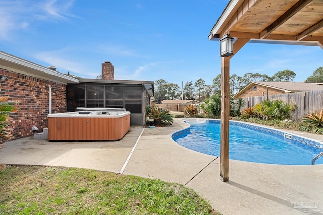 view of swimming pool with a patio area, a hot tub, and a sunroom