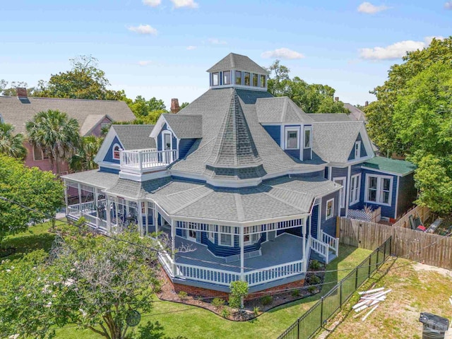 back of property with a balcony and a yard