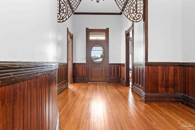 entryway with crown molding and light hardwood / wood-style flooring