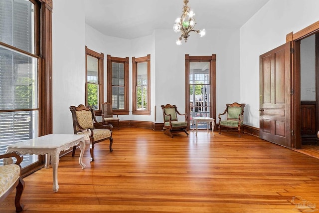 sitting room featuring an inviting chandelier and light wood-type flooring