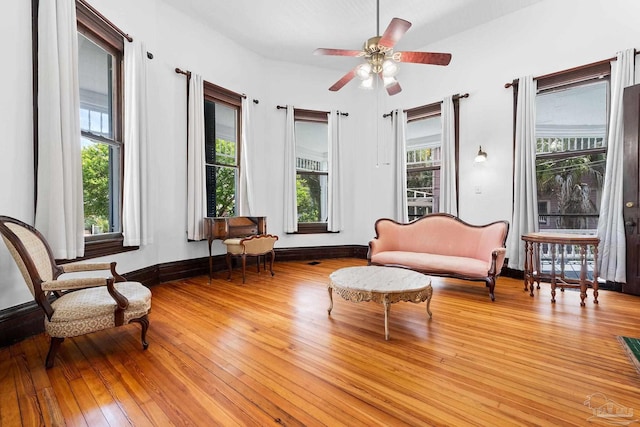 living area with ceiling fan and light hardwood / wood-style floors