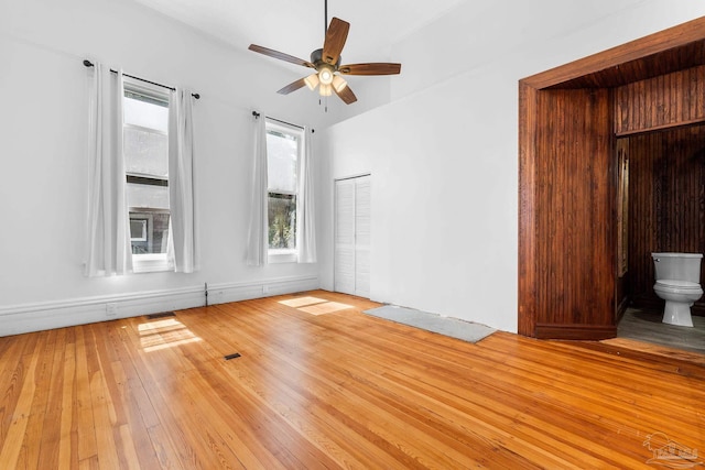 spare room with ceiling fan, vaulted ceiling, and light hardwood / wood-style floors