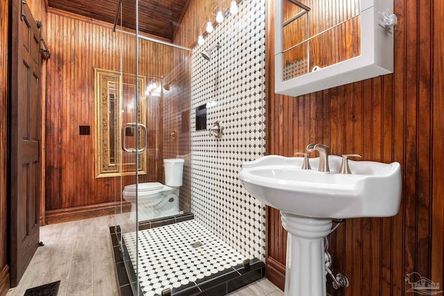 bathroom featuring an enclosed shower, wood ceiling, wooden walls, and toilet