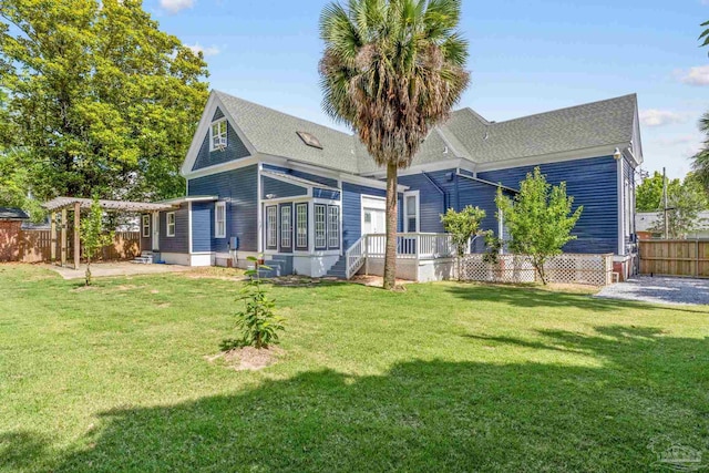 rear view of house featuring a lawn