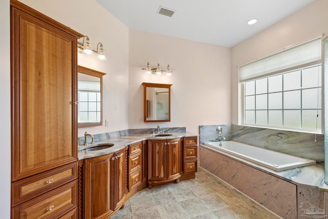 bathroom featuring tiled bath and vanity