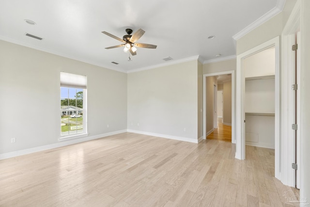 unfurnished bedroom featuring ceiling fan, ornamental molding, a spacious closet, and light hardwood / wood-style flooring