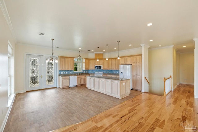 kitchen featuring hanging light fixtures, white appliances, light hardwood / wood-style floors, a kitchen island, and ornamental molding