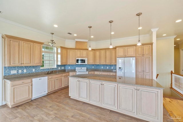 kitchen with a center island, white appliances, stone countertops, and light hardwood / wood-style floors