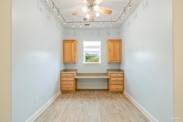 unfurnished office featuring ceiling fan, light wood-type flooring, and track lighting