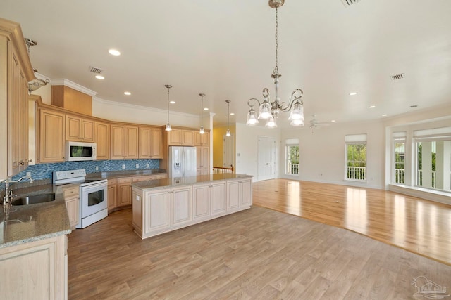 kitchen featuring white appliances, pendant lighting, and light hardwood / wood-style floors