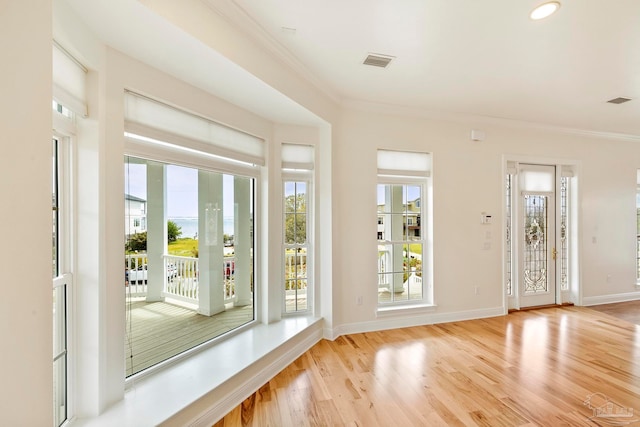 doorway to outside with light hardwood / wood-style flooring and ornamental molding