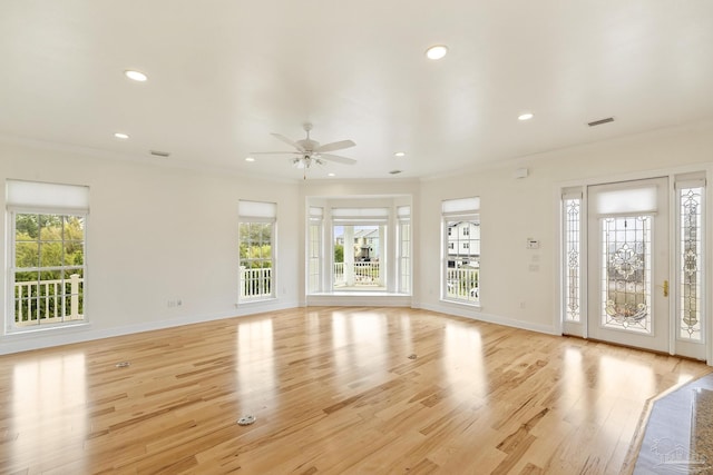 unfurnished living room featuring ceiling fan, ornamental molding, and light wood-type flooring