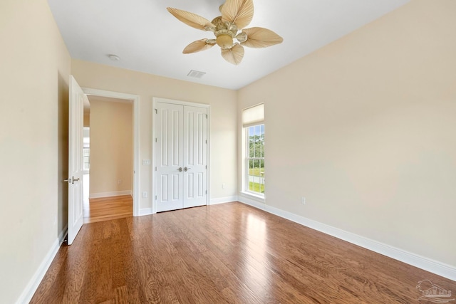 unfurnished bedroom with a closet, ceiling fan, and dark hardwood / wood-style floors