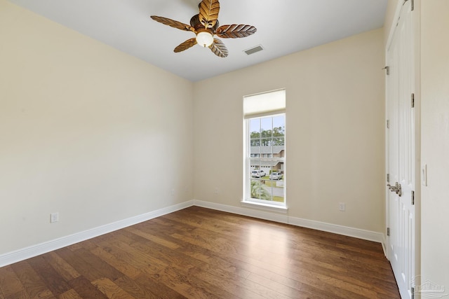 spare room featuring dark wood-type flooring and ceiling fan