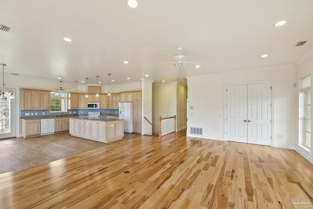 kitchen with white appliances, a center island, tasteful backsplash, decorative light fixtures, and light wood-type flooring