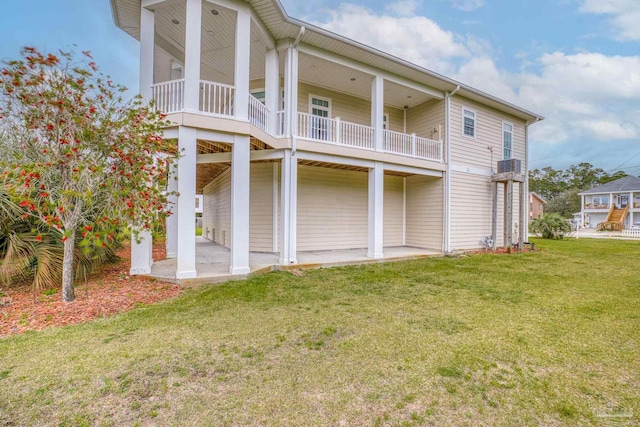 rear view of house featuring a yard and a patio