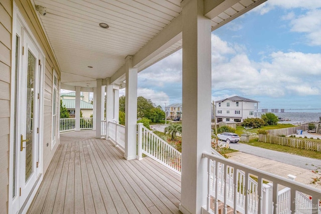 wooden deck featuring a water view and a porch