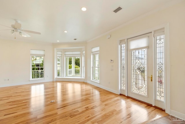 entryway with light wood-type flooring, ornamental molding, and ceiling fan