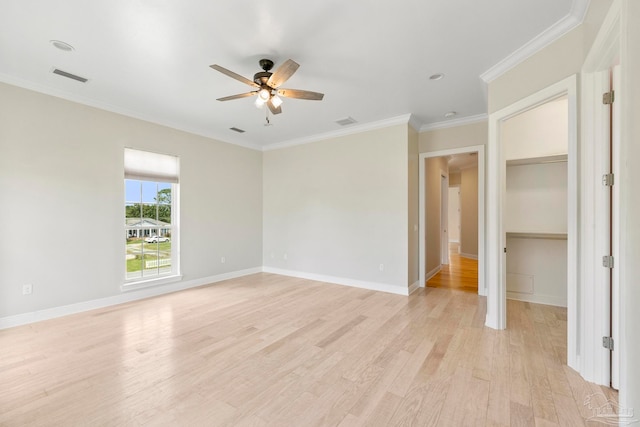 unfurnished bedroom with light wood-type flooring, ornamental molding, a walk in closet, and ceiling fan