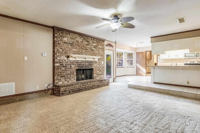 unfurnished living room featuring light carpet, a textured ceiling, and a brick fireplace