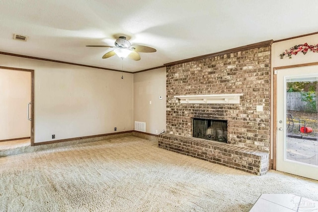 unfurnished living room with carpet flooring, ceiling fan, crown molding, and a brick fireplace