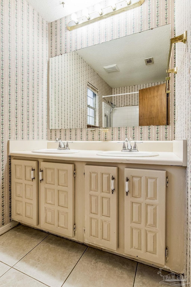 bathroom featuring tile patterned flooring, a textured ceiling, and vanity