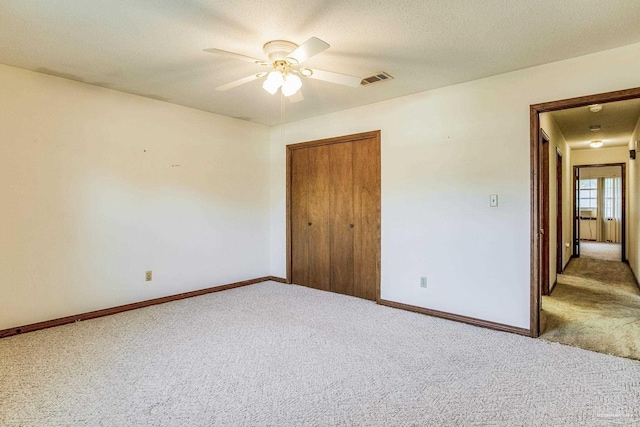 unfurnished bedroom featuring carpet flooring, a closet, and ceiling fan