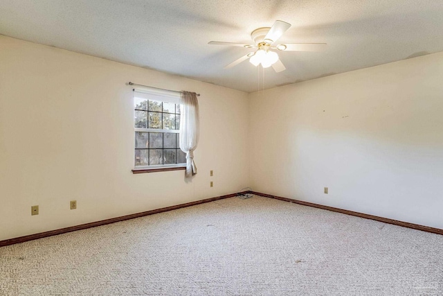 carpeted spare room featuring ceiling fan and a textured ceiling