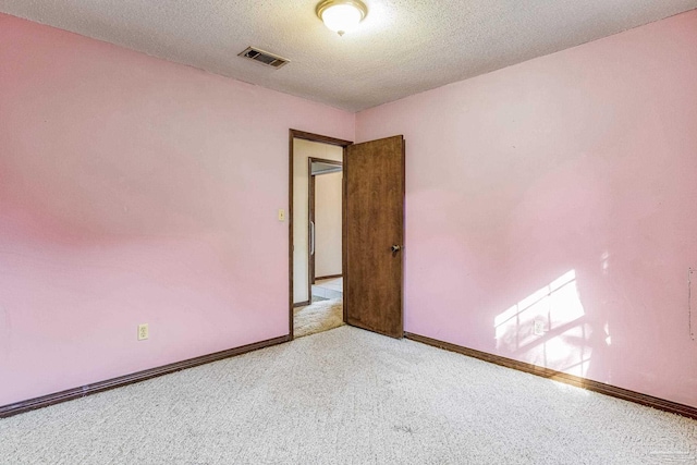 spare room with carpet floors and a textured ceiling